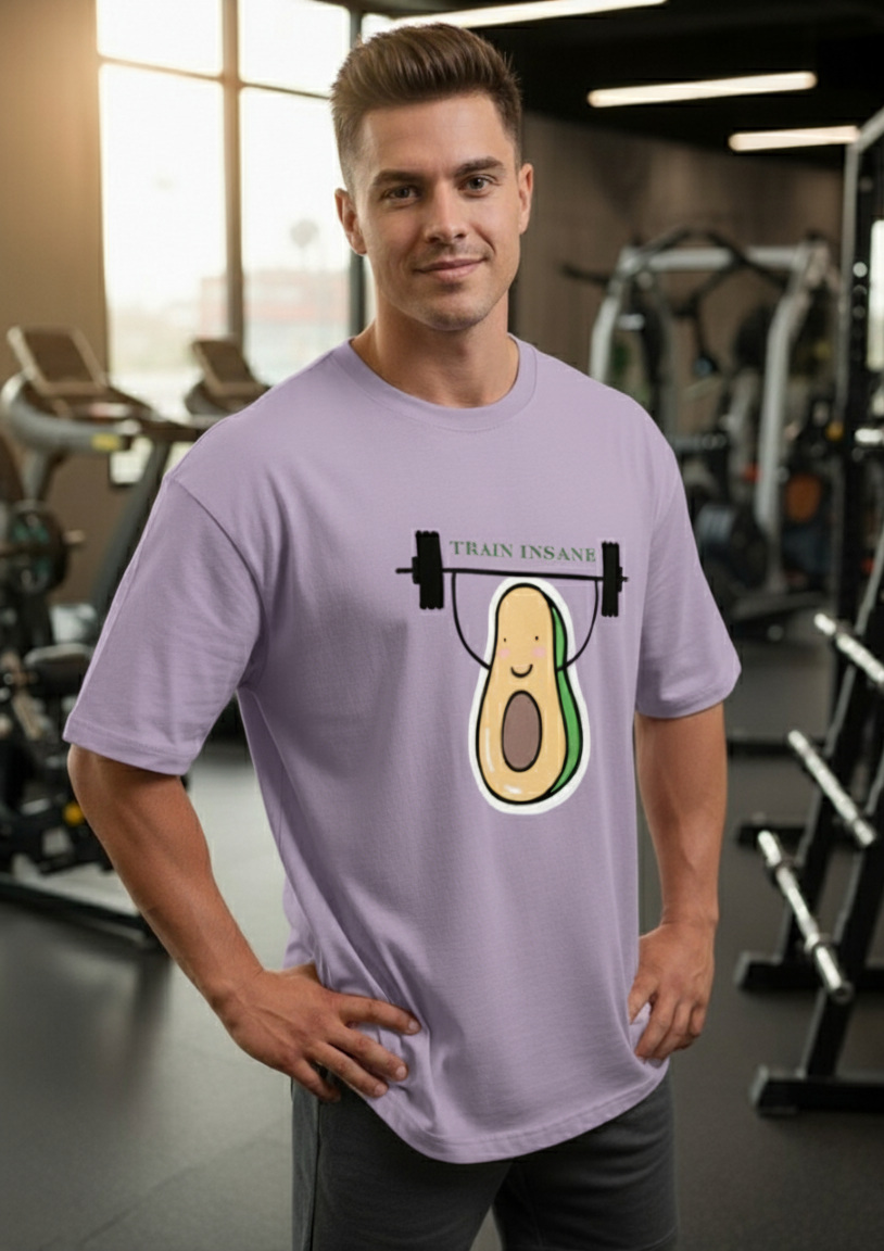 Man wearing a lavender t-shirt with an avocado lifting weights graphic in a gym.