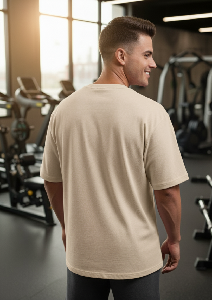Man in a beige t-shirt standing in a gym
