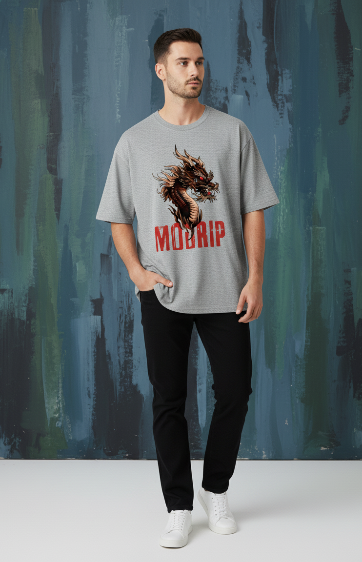 Man wearing a grey melange t-shirt with a dragon graphic and 'MODRIP' text against a textured wall.