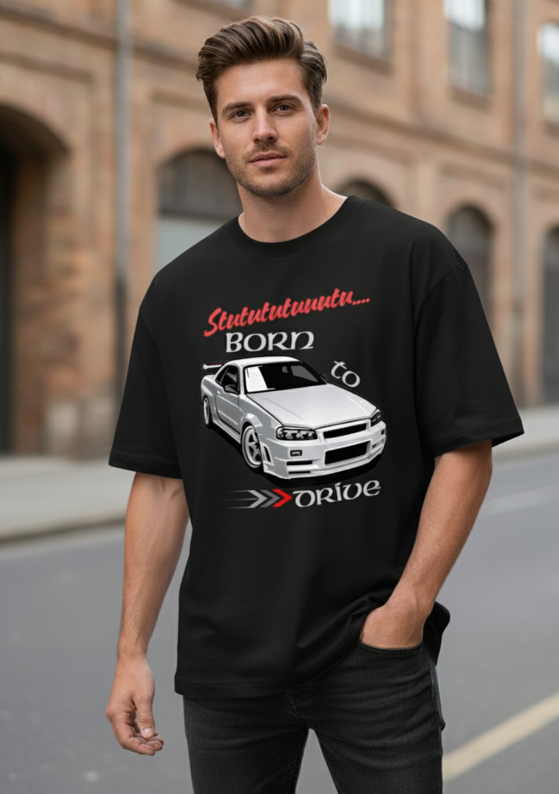Man wearing a black t-shirt with a graphic design of a car and text, standing on a street.