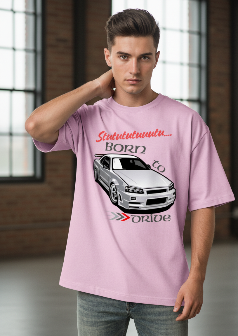 Man wearing a light baby pink t-shirt with a car graphic and text in an indoor setting